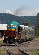 13.7.2012 Parkdale, OR. #0202 der Mt. Hood Railroad bei der Einfahrt - im Hintergrund Mt. Rainier, WA. Die beiden Domcars stammen von der Holland - America - Line (zumindest war ein derartiger Schriftzug erkennbar) und stammen aus den 60ern. Die kleine Bahngesellschaft betreibt auch Gterverkehr.