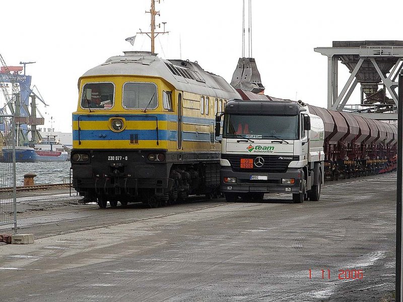 TLG 230 077 beim betanken am Verladekai im Rostocker Seehafen. Im Hintergrund sieht man wie die Wagen beladen werden.

