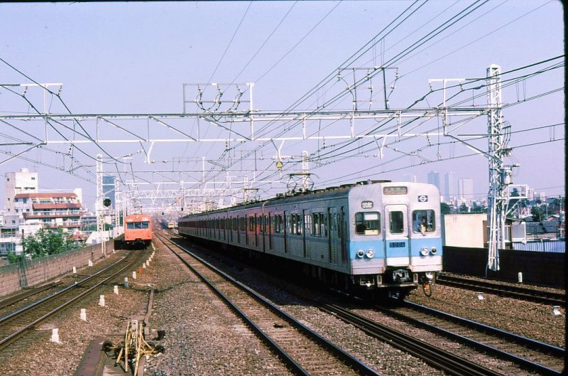 Tokyo Metro Tôzai-Linie (Ost-West-Linie): Die zwischen 1964 und 1981 gebauten Züge Serie 5000 (total 428 Wagen), die in Tokyo auf zwei U-Bahnlinien eingesetzt wurden, sind bis 2007 ausgeschieden; 30 Wagen fahren seit 2006 in Jakarta (Indonesien). Im Bild Zug mit Endwagen 5004 in Tokyo-Asagaya; im Hintergrund die damals erst ganz wenigen Hochhäuser von Tokyo. 6.September 1979.  