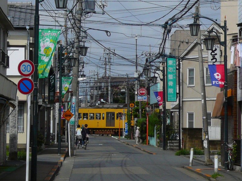 Tokyo S-Bahn, Feinverteilerbahnen :Seibu-Konzern.In  klassischer  Weise führt diese Feinverteilerstrecke durch und quer über die kleinen Quartiersträsschen der westlichen Vororte von Tokyo. Bild: Wagen 217 auf einer Kreuzung zwischen (Tokyo-)Musashi Sakai und Shin Koganei, 31.August 2008.