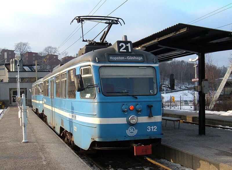 Triebwagen 312 mit Steuerwagen 613 der Lidingbanan am 15.01.2006 nach Gashaga in der Endstation Ropsten. Diese Bahn ist die einzige Linie, die in Stockholm noch mit lteren Straenbahnwagen fhrt. Im Hintergrund links die Endstation Ropsten der Tunnelbanan rot.