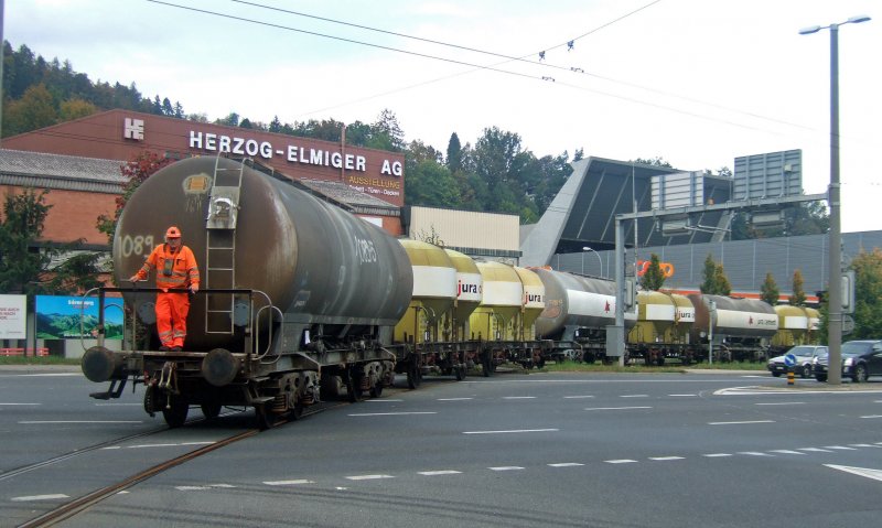 Tckisch: Ein leerer Zementwagenzug berquert am 09.10.09 in Kriens die Kreuzung der Hauptstrasse und der Autobahnausfahrt. In dieser Umgebung findet sich die beste Rechtfertigung, warum SBB Cargo mit Diesel rangiert. Dieses Anschlussgleis kreuzt eine Trolleybuslinie und fhrt entlang der Zentralbahn.