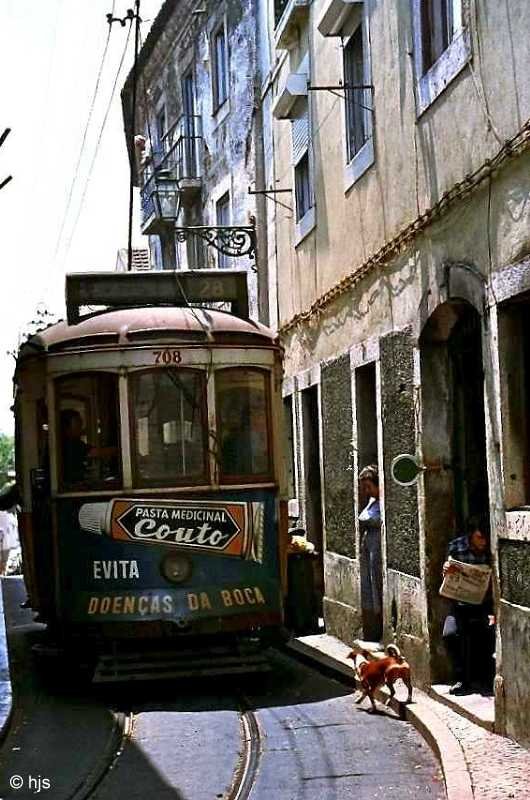 Tw 708 passiert einen Streckenposten auf dem eingleisigen Abschnitt der Linie 28 durch die Alfama (16. Juni 1986). Der Zeitungleser im Hauseingang rechts ist fr die Bedienung der Signalscheibe zustndig. Ob auch der Hund eine offizielle Funktion hat, ist nicht bekannt ;-). Seit 1990 erfolgt die Verkehrsregelung durch eine Lichtzeichenanlage.