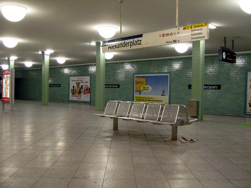 
U-Bahnhof Alexanderplatz: Der Bahnhof besitzt rechteckige gruene Fliesen, die Sttzen wurden unverkleidet gelassen. Geplant als grosse Umsteigeanlage fr 4 Linien wurden fr die U8 neben der U5 und der geplanten U3 Stationen angelegt. Die Eingaenge wurden jedoch teilweise ab 1961 zugemauert.
