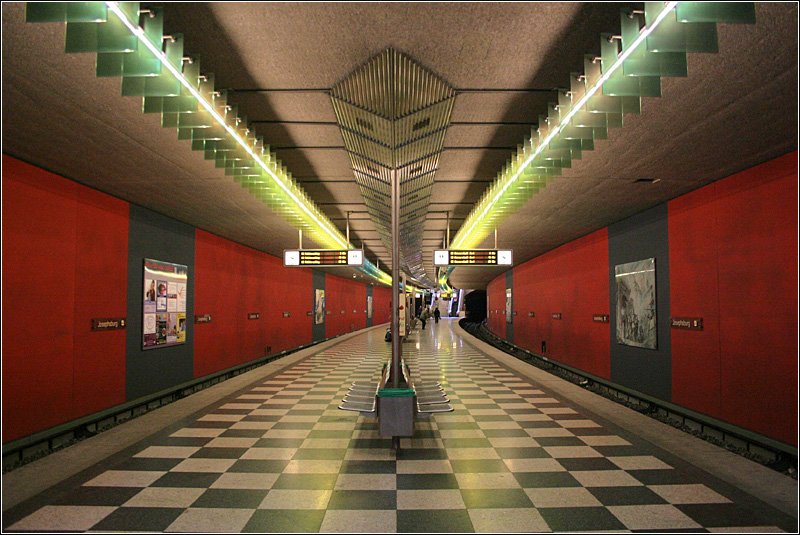 U2-Ost, Josephsburg (1999) - 

Nachdem der Münchener Flughafen 1992 ins Erdinger Moos verlegt worden war, konnte das bisherige Gelände in Riem anderer Nutzung zugeführt werden. Die Messe wurde dorthin verlegt und zudem ausgedehnte Wohnbauflächen erschlossen. Mit einem neuen 7,7 km langen Streckenast vom bestehenden viergleisigen Bahnhof Innsbrucker Ring aus wurde der neue Stadtteil ab 29.5.1999 an das U-Bahnnetz angeschlossen. Josephsburg ist der erste von sechs Bahnhöfen dieses Streckenabschnittes. Verbindendes gestalterisches Element der meisten dieser Stationen ist die Farbe Rot. 

03.04.2007 (M)
