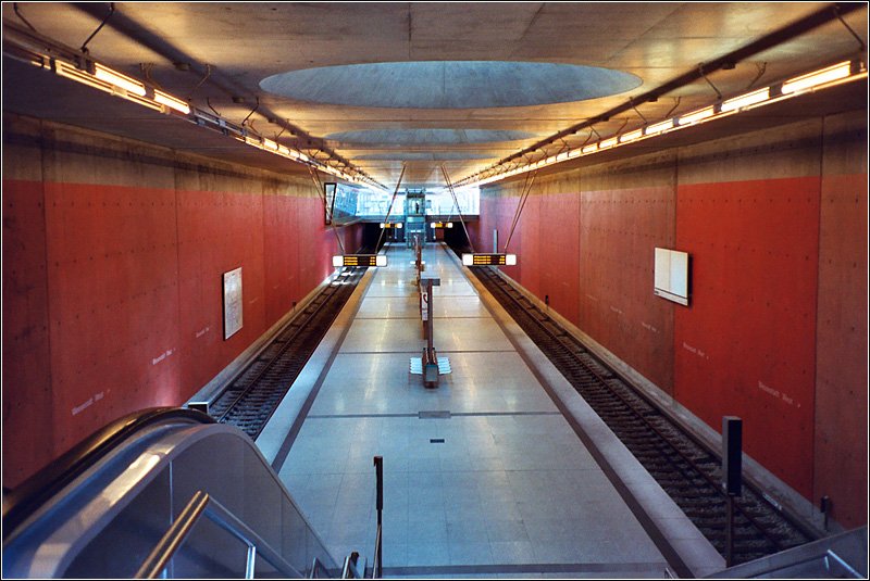 U2-Ost, Messestadt-West (1999) - 

Dieser Bahnhof liegt auf dem ehemaligen Münchener Flughafengelände. Sichtbeton (an den Wänden rot eingefärbt) mit Oberlichter prägt hier die hohe Bahnsteighalle. 

Scan, 2003 (M)