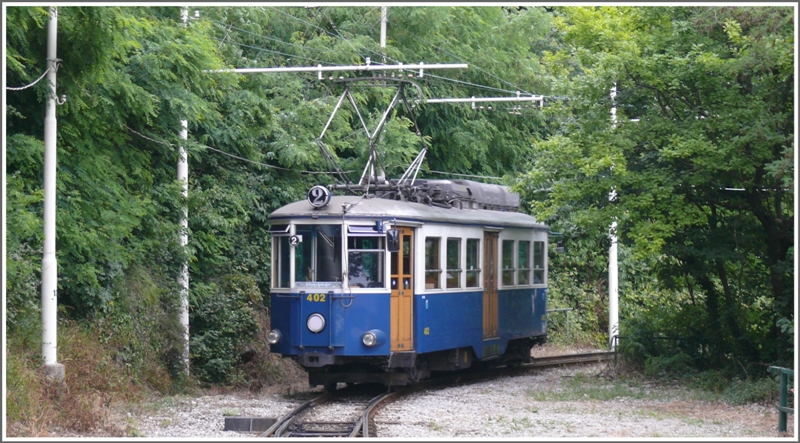 �ppig wuchert das Gr�n an den Abh�ngen �ber der Stadt Trieste, wo uns an einer der zahlreichen Ausweichstellen Tramwagen 402 kreuzt. (08.06.2009)