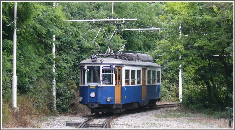 ppig wuchert das Grn an den Abhngen ber der Stadt Trieste, wo uns an einer der zahlreichen Ausweichstellen Tramwagen 402 kreuzt. (08.06.2009)