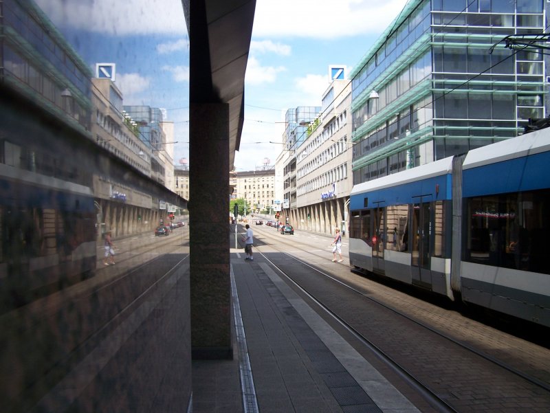 Unbekannter Stadtbahnzug verlsst die Haltestelle Kaiserstrae im Saarbrcker  Bankenviertel  in Richtung der Haltestelle Hauptbahnhof (Stadtbahn) und spiegelt sich dabei in den Marmorpfeilern des Gebudes der Bank1Saar - rechts zu sehen die Gebude von HypoVereinsbank, Deutscher Bank und Saarlndischer Landesbank (29.07.2008).