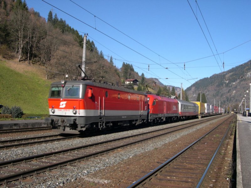Und wieder erwischen wir 1044 019-6 am 28.10.2005. Diesmal in Dorfgastein und mit 1116 103-9 und einer weiteren Rollenden Landstrae im Schlepptau. Hier fahren die beiden Loks mit Streckenhchstgeschwindigkeit bergwrts, denn sie werden verfolgt ...