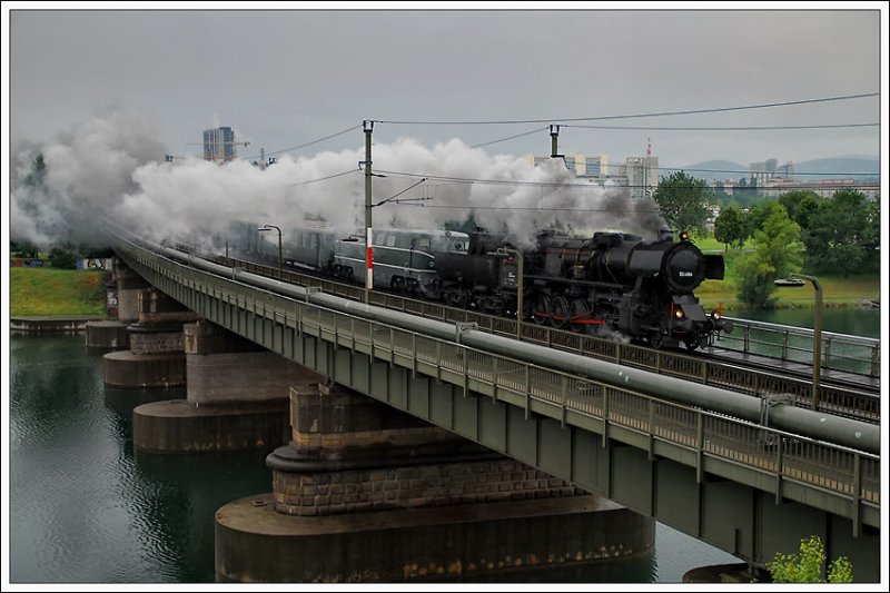 Unter dem Motto „Zur Sonnwendfeier in die Wachau“ stand die Tour O22 der BB Nostalgie am 20.6.2009. Zu diesem Anlass wurde Sdz R 16344 von Wien nach Spitz in Verkehr gesetzt. Wegen dem Stellwerksausfall in Senbrunn, musste der Zug ber den Wiener ZVB und die Stammstrecke umgeleitet werden. Das Foto zeigt den Zug mit 52.4984 als Vorspannlok vor 2050.02 und elf Waggons bei der Querung der Neuen Donau kurz vor der ehemaligen S-Bahnhaltestelle Wien Strandbder. Wetter: OHNE WORTE, aber bei Sonnenschein wre die Aufnahme gar nicht mglich gewesen, da erst um 13:58 in Wien abgefahren wurde und die Sonne direkt gegenber dem Fotografen gestanden wre.