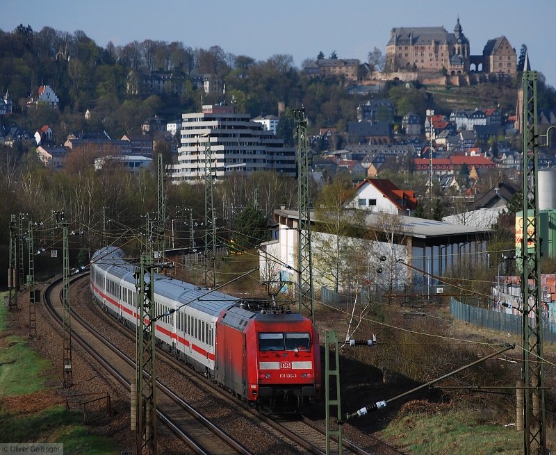 Unterm Marburger Landgrafenschloss (I) –  Hier beginnt der dritte und letzte Teil der Trilogie aus Marburg – Gerade fhrt IC 2276 (KA−HH) mit 101 100-3 nach Marburg ein. In der Kurve beginnt heute der Bahnhof Marburg Sd. Dieser Bahnhof ist fast vollstndig zum Haltepunkt degradiert, einzig zwei Weichen zum Spurwechsel in nur eine Richtung erlauben noch die Bezeichnung Bahnhof. Rechts der Bereich mit dem Gestrpp war bis 2005 noch mit den Gleisanlagen der einstigen Bahn in den Ebsdorfer Grund versehen, die wohl als Kopfbahnhof hinter dem Staatsbahnhof endete. Rechts vor der gewerblichen Halle ist noch ein mittlerweile sinnloser Minibahnbergang fr Radfahrer. Die Gleise liegen nur noch unter dem Teer, einst die Zufahrt zum Tanklager, rechts angedeutet. (07. April 2007, 17:17)