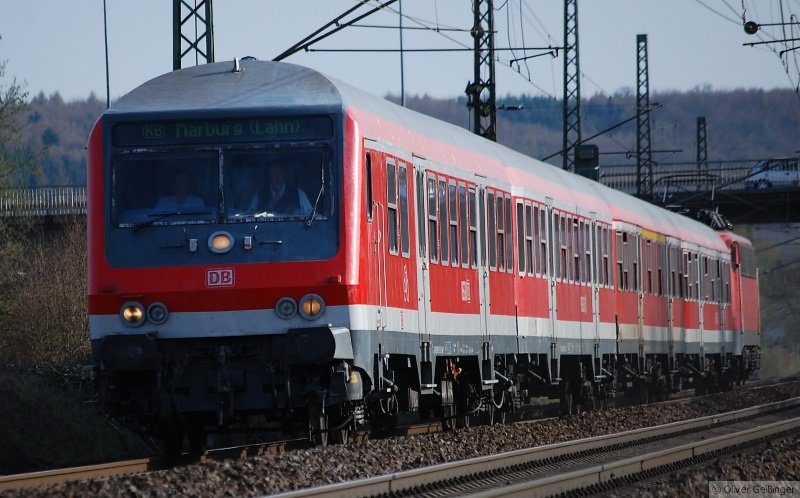 Unterm Marburger Landgrafenschloss (VII). Es n�hert sich dem Halt in Marburg S�d RB 25062 aus Gie�en mit Silberlingen und B�gelfalte 110 429-8. Diese verkehrt nur noch in einzelnen Zugpaaren. Hier steht jeder Mast krumm und der Zug legt sich auch langsam in die Kurve, so dass es schon recht schwer ist die Kamera gerade zu halten. (07. April 2007, 17:36)