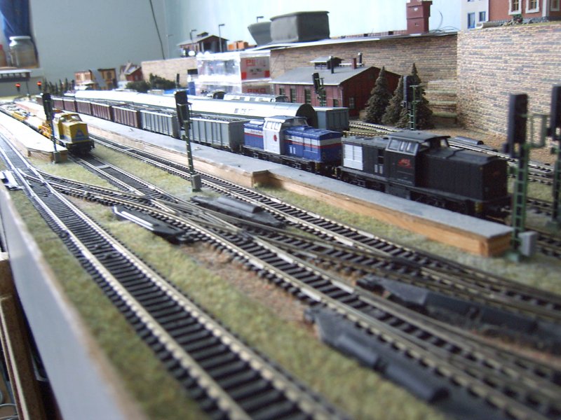 V 100 in Doppelpack.Die schwarze ist von rt&l und die andere ist von rent a rail.Sie ziehen 9 Hochbordwagen mit Eisenspne beladen.