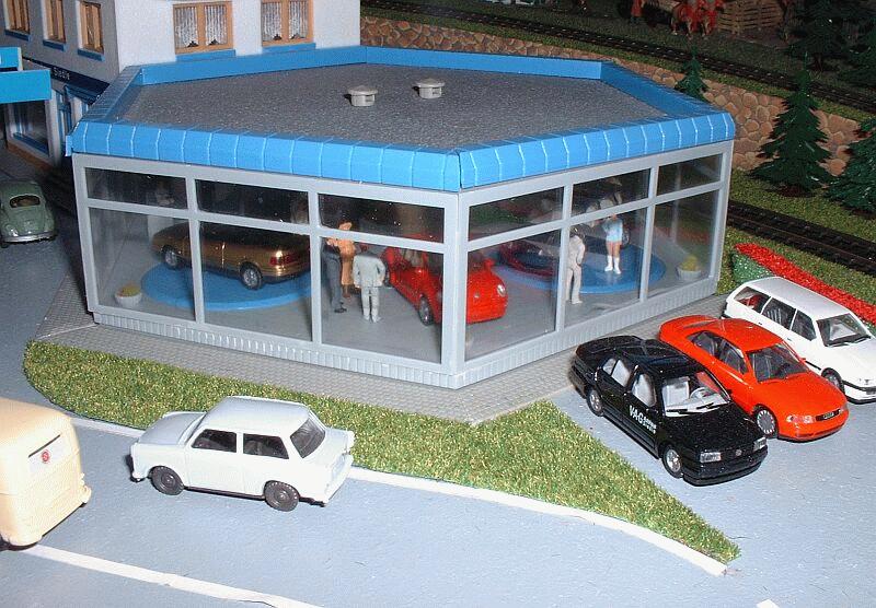 VAG-Autohaus (Faller 348) neben dem Fernsehturm. Die beiden Teller mit Autos und junger Dame werden von einen Motor angetrieben.
