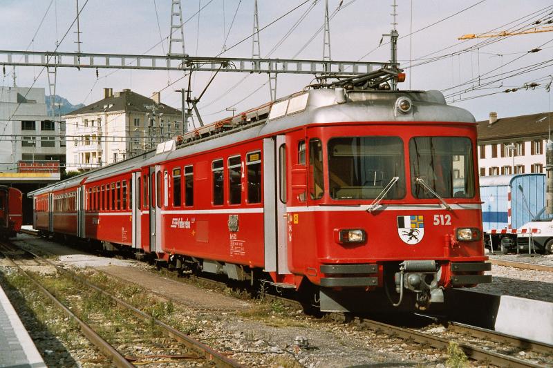 Vierteiliger Vorortstriebzug Be 4/4 Nr. 512 + B 2412 + B 2418 + ABDt 1712 der Rhtischen Bahn in Chur als Regionalzug nach Kblis am 20. September 2004. Diese  Rhtischen Roten Pfeile  kamen 1971 und 1979 in sechs Exemplaren in Betrieb und waren die ersten Streckentriebfahrzeuge der RhB mit Thyristor-Phasenanschnittsteuerung.