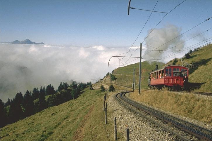 Vitznau-Rigi Bahn (VRB) Mit Volldampf auf den Gipfel,links die Gleise der ehemaligen Arth-Rigi Bahn (ARB) Heute eine Bahngesellschaft.Beide Bahngesellschaften hatten dazumal ein eigenes Trasse auf die Rigi ( Die Knigin der Berge )gebaut