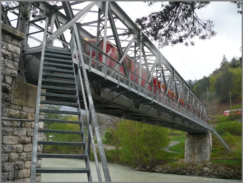 Vom Regen berrascht suche ich Schutz unter der Vorderrheinbrcke bei Reichenau-Tamins.Whrend RE1250 nach Ilanz ber die Brcke donnert, nhert sich R1558 von Rhzns der Streckenverzweigung. (21.04.2009)