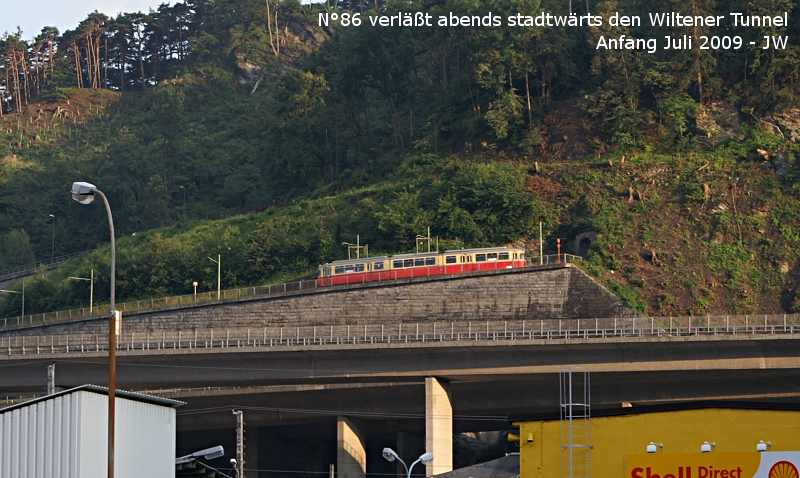 Von der Kreuzung vor der Pfarrkirche Wilten-West aus beobachtet: N86 der Stubaitalbahn hat den Wiltener Kehrtunnel talwrts passiert und glnzt in der Abendsonne. Ende Juni/Anfang Juli 2009 kHds