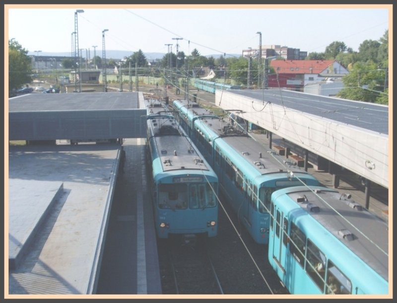 Von der Maybachbr�cke aus bietet sich ein direkter Blick in die U-Bahn-Station Heddernheim und die M�glichkeit, den Z�gen auf das Dach zu schauen. Am 24.07.2008 fuhr im Bild links gerade der 2. Zug der Linie U1 zum S�dbahnhof mit den U2h-Triebwagen 308 und 354 ein, die Linie sowie die Wagennummern des Zuges auf dem Gegengleis konnte ich leider nicht registrieren. 