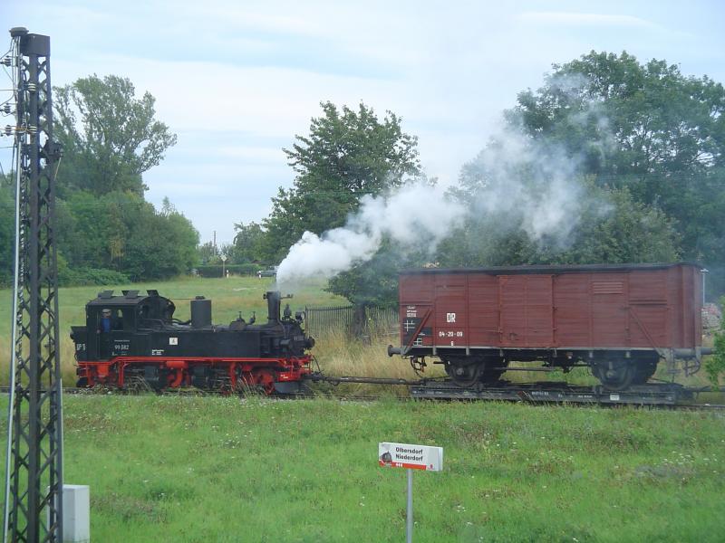Von meinem Fenster aus fotografiert: Strecke Zittau-Oybin/Jonsdorf, Bahnhof Olbersdorf-Niederdorf, Einfahrt des Gterzuges mit der IV-K-Lok 99-582 mit Rollwagen. Sieht man nicht alle Tage.