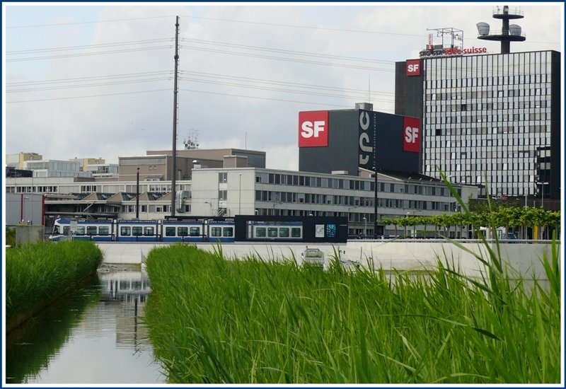 Vor dem Fernsehstudio wurde eine knstliche Landschaft mit einem See, einem Sandstrand auf der einen- und einem Schilfgrtel auf der andern Seite geschaffen. Neben viel Beton wurden auch viele Bume gepflanzt und Parkanlagen geschaffen. Die ganze Anlage dient als Regenrckhaltebecken bei Starkniederschlgen. Die Wetterprognosen des Schweizer Fernsehen erfolgen vom Dach des rechten Gebudes. Ein Be 5/6 Cobra hlt an der Haltestelle Fernsehstudio. (18.06.2008)