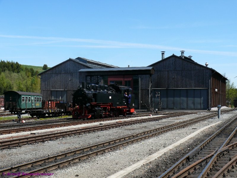 Vor den holzverkleideten Werkstattgebuden der SDG-Fichtelbergbahn dampft die 99 772 unter dem Bockkran.
11.05.2008 Oberwiesenthal
