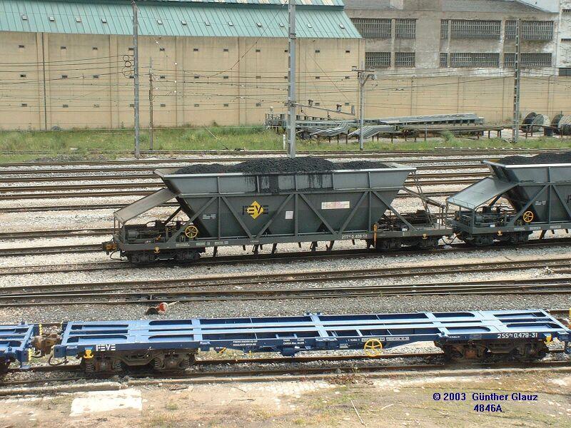 Vorn leerer Container-Tragwagen, hinten Schttgutwagen mit Eisenerz oder Koks fr das Stahlwerk Barreda am 09.05.2003 im Gterbahnhof Santander.