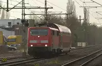 Aus dem Gegenlicht kommt die 111 093 mit einem Dostock als PbZ gen Neuss fahrend in Korschenbroich. 14.3.2017