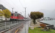 Nicht immer zeigt sich das Wetter von seiner schönen Seite. Bei trüben und regnerischen Bedingungen fährt die Re 4/4 II 11194 mit einem Interregio aus dem Bahnhof Flüelen. 14.10.2016