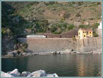 Eine E633 f�hrt einen G�terzug am Hafen von Vernazza vorbei Richtung Genova. Nur das nordw�rts f�hrende Geleise liegt hier ausserhalb des Tunnels. (27.04.2007)