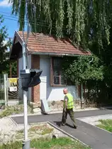 Der  Schrankenwärter  geht wieder in sein Häuschen am Bahnübergang vor Miskolc-Majlath, 10.7.16 

Ein kurzes Video der Straßenquerung gibt es hier:
http://www.bahnvideos.eu/video/Ungarn~Schmalspurbahnen~Miskolc+LAEV/20748/lok-d02-510-der-laev-kreuzt-die.html