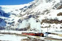 RhB - Dampfschneeschleuderextrazug 9462.2 f�r Graub�nden Tours von Alp Gr�m nach Ospizio Bernina am 28.02.1998 oberhalb Alp Gr�m mit Dampfschneeschleuder X d rot 9213 - Triebwagen ABe 4/4 I 30 + ABe 4/4 I 30. Hinweis: Blick links oben auf Pal�-Gletscher, Triebwagen verkehren heute in gelber Lackierung, gescanntes Dia.
