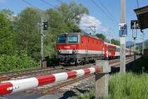 Zwischen der Haltestelle Grieswirt und dem Bahnhof St. Johann in Tirol zieht 1144 215 die Wagen des von Salzburg kommenden REX 1520 nach Wörgl (26.05.2017).