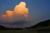 Es ist schon Nacht geworden, und so ist der BLS-Triebzug  Mutz  Serie 515 kaum noch sichtbar. Doch die Gewitterwolke türmt sich so hoch, dass sie noch rotes Sonnenlicht bekommt. Bei Kehrsatz, 25.Juni 2017 