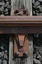 In Wefensleben waren die Weichen des stillgelegten Geisanschlusses noch aus Reichsbahn Zeiten, was gut an den Rippenplatten und Gleitstuhlplatten zu sehen ist.
Hier ist eine RPG23 zu sehen. Anders als heute befindet sich der Bügel auch Fisch genannt da er heute Fsh abgekürzt heißt außerhalb der Platte. Heite befinden sich die Bügel der Inneren Backenschienenverspannung unter der Gleitstuhlplatte.

Wefensleben 31.07.2017