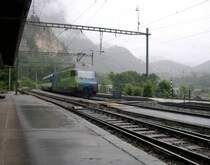 Die f�r den Verkehrsclub Schweiz werbende 460 079-7 schiebt am 01.07.2005 bei regnerischem Wetter einen InterCity an der L�tschberg Nordrampe talw�rts. Gleich sieht man den Zug rechts unten nochmal, hier aber leider nicht im Bild. Das Bild entstand im Bahnhof Blausee-Mitholz. Trotz das in diesem Bahnhof t�glich nicht mehr wie drei Reisez�ge halten, ist er sehr aufger�umt. Es liegt kein M�ll in der Gegend rum, die Bahnsteige sind frei von Unkraut und es hat sogar eine ge�ffnete �ffentliche Toilette. Ein Luxus den man in Deutschland auf einem Bahnhof dieser Gr��enordnung schon lange nicht mehr antrifft!