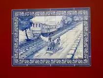 CAMINHO DE FERRO DO MONTE, Madeira
Die Caminho de Ferro do Monte war die einzige Eisenbahnstrecke mit Personenverkehr auf der portugiesischen Insel Madeira. Die Zahnradstrecke führte mit 3,911 km von der Station Pombal in Funchal via Levada de Santa Luzia, Livramento, Sant'Ana- Flamengo und Confeitaria nach Monte. Im Bahnhof  Monte beginnt der 3. Streckenabschnitt, wurde am 24. Juni 1912 in Betrieb genommen und bis nach Terreiro da Luta. Dazu hatte eine Dampflok mit 3,911 km ganze 850 m über den Meeresspiegel überwunden.

Heute existieren noch in Monte das ehemalige Stationsgebäude und die Eisenbahnbrücke. Das Bild zeigt ein Azulejo (ein Bild aus zumeist quadratischen, bunt bemalten und glasierten Keramikfliesen) mit einem der 5 Dampfloks (vier von der Maschinenfabrik Esslingen und eine von der SLM Winterthur erbaut) sowie eine der fünf Personenwagen (mit einer Kapazität für je 60 Personen)der Caminho de ferro da Monte bei der Runterfahrt nach Pumbal. Rechts sieht man noch einen Korbschlitten. Das Bild entstand am 18. April 2017 in Monte(mache am ehemaligen Bahnhofsgebäude)