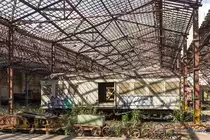 Impressionen aus dem ehemaligen Bw Jundiai der Companhia Paulista (CP), das heute ein Eisenbahnmuseum beherbergt. In Brasilien gibt es heute mit Ausnahme des städtischen Personenverkehrs und der privaten Bahnen der Minengesellschaften im Norden kein Eisenbahnnetz mehr. Bei den hier gezeigten Bildern handelt es sich um den traurigen Rest der brasilianischen Eisenbahn. Dieser Gepäckwagen befindet sich in Privatbesitz und damit besteht noch eine kleine Hoffnung auf Restauration. Beim staaatlichen Museum besteht kein sonderliches Interesse an der Erhaltung des rollenden Materials. Es werden lediglich einige Einzelteile, die man für erhaltenswert erachtet demontiert und in den Museumsräumen ausgestellt.

Mir ist durchaus bewusst das Graphity zur Ablehnung des Bildes führen kann. Doch handelt es sich dabei um ein globales Problem, dass wir mit Verschweigen nicht lösen werden. Und in Anbetracht des desolaten Allgemeinzustandes (dieser Wagen ist dank Privatbesitz noch recht gut erhalten) ist das bischen Sprühfarbe noch das geringste Problem. 12.10.2017