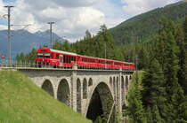 Mit dem Steuerwagen 1758 vorraus fährt R1937 (Scuol-Tarasp - Pontresina) über das Inn-Viadukt bei Cinuos-chel-Brail. Hinten schiebt Ge 4/4 613  Domat/Ems .

Cinuos-chel-Brail, 15. Juni 2017