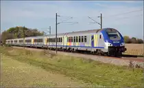 Bahn im Elsass. Ein TER f�hrt im fahlen Licht der Wolke aus Saharasand und Waldbrandasche von M�lhausen Richtung Basel. Bartenheim, Oktober 2017.