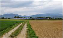 Bahn im Elsass. Bild mit dem Menschenfresserberg alias Hartmannsweilerkopf links im Bild, der gerade aktuell ein Thema der deutsch-franz�sischen Beziehungen war, siehe auch n�here Beschreibung bei Bild 1051431. Rechts im Hintergrund mit dem gro�en Belchen der h�chste Berg der Vogesen. Davor zieht der TGV Duplex 4708 Richtung Stra�burg seines Weges. Raedersheim, Oktober 2017.