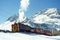 RhB - Dampfschneeschleuderextrazug 9462.2 f�r Graub�nden Tours von Alp Gr�m nach Ospizio Bernina am 28.02.1998 oberhalb Alp Gr�m mit Dampfschneeschleuder X d rot 9213 - Triebwagen ABe 4/4 I 30 + ABe 4/4 I 30. Hinweis: Triebwagen verkehren heute in gelber Lackierung, gescanntes Dia.
