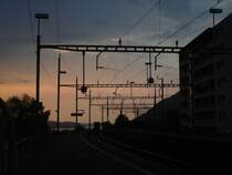 Sonnenuntergang im Bahnhof von Arth-Goldau, �ber dem Dorf tobt ein Gewitter. Blick Richtung Zug, 28.4.2007.