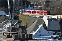 Brückenbaustelle Neue RhB-Hinterrheinbrücke bei Reichenau-Tamins. Ein riesiger Liebherr Kran wurde montiert, um die neue Brückenteile zu positionieren. S1 1519 mit Allegra 3104. (25.12.2017)