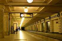 Einen Hauch von Rheintal. 
Der U-Bahnhof Rüdesheimer Platz  eröffnet am 12. Oktober 1913 entstand im Rahmen des Baus der Wilmersdorf-Dahlemer-Untergrundbahn zwischen Wittenbergplatz und Thielplatz im Süden der Domäne Dahlem. Da die Gemeinde Wilmersdorf aus Prestigegründen großen Wert auf eine repräsentative Gestaltung der Bahnhöfe legte, beauftragte sie den Architekten Wilhelm Leitgebel, diese Aufgabe zu übernehmen.

Leitgebel, der auch die Nachbarbahnhöfe Breitenbachplatz und Heidelberger Platz entwarf, wählte für die Untergrundstation vornehmlich Motive des Weinanbaus; die benachbarten Straßennamen des Rüdesheimer Platzes sollen ihn dazu inspiriert haben. In der Bahnsteigmitte befinden sich jeweils achteckige Granitpfeiler mit runden Stützen, die die verputzte, kassettenförmige Decke tragen. Jeweils in einer Kassette befinden sich die Leuchtelemente, umgeben von Mosaiken. Die Bahnsteigwände bestehen jeweils aus Nischen, dabei abwechselnd flache, als Werbeflächen gedachte Nischen, und halbrunde, die die aus Mosaiken bestehenden Stationsschilder tragen. Die Bahnsteigwände werden jeweils von einem dunkelgrünen Keramikstreifen abgeschlossen. Für die ebenfalls angebrachten, kleinen Tierplastiken aus Keramik (Weinlaub, Trauben, Insekten und Kriechtiere: alles zum Thema Leben in einem Weinberg) war der Künstler Martin Meyer-Pyritz verantwortlich. Die beiden Zugänge, gelegen auf einer Mittelinsel in der Rüdesheimer Straße, gestaltete Wilhelm Leitgebel mit steinernen Treppenumwehrungen und jeweils zwei mit Lampen ausgestatteten Pylonen. Für die aus Metall bestehenden Zugangstore wählte Leitgebel Andreaskreuze, Rosetten und Weintrauben als Gestaltungsmerkmale.

Berlin Wilmersdorf 03.01.2018


Seite „U-Bahnhof Rüdesheimer Platz“. In: Wikipedia, Die freie Enzyklopädie. Bearbeitungsstand: 17. Juni 2017, 10:27 UTC. URL: https://de.wikipedia.org/w/index.php?title=U-Bahnhof_R%C3%BCdesheimer_Platz&oldid=166472661