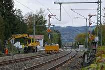 Nachdem in Lindau der Bahnübergang  Langenweg  durch eine Brücke ersetzt wurde (im Bild nur schwer erkennbar durch den helleren Schotter hinter den Flügelsignalen) und die alten Oberleitungsmasten durch neue ersetzt wurden, ist am 22.10.2017 ein Zweiwegebagger mit Arbeiten an der Böschung beschäftigt.