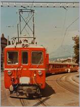 Der RhB Gleichstromtriebwagen ABDe 4/4 486 der Arosabahn wartet in Chur auf dem Bahnhofsplatz mit einem stattlichen Zug auf die Abfahrt nach Arosa.
13 August 1984