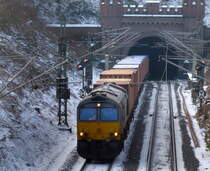 Die Class 66 DE6307 von Crossrail  kommt aus dem Gemmenicher-Tunnel raus mit einem MSC-Containerzug aus Antwerpen-Krommenhoek(B) nach Germersheim(D)  und fährt nach Aachen-West und rollt die Gemmenicher-Rampe herunter nach Aachen-West. 
Aufgenommen in Reinartzkehl auf der Montzenroute.
Bei Sonnenschein und Schnee am Kalten 9.2.2018.