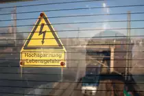 Ein Schild an der Brücke nahe der Kasseler Straße in Halle (Saale) warnt vor Hochspannung an der Oberleitung.
Im Hintergrund fährt eine BR 9442 (Bombardier Talent 2) von Abellio Rail Mitteldeutschland als RB 74621 (RB20) von Eisenach nach Halle(Saale)Hbf fährt dort auf der Bahnstrecke Halle–Bebra (KBS 580). [29.12.2017 | 14:28 Uhr]